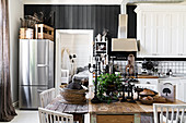 Three wooden tables in dining area of vintage-style country-house kitchen