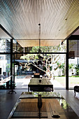 View across counter to dining table in open-plan interior with glass wall