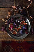 A still life with fresh figs, dried grapes and grapevine branches
