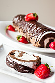 Chocolate roulade cake with chocolate drizzle and fresh powdered sugar