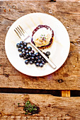 Southern style shortcake with blueberry compote, vanilla ice cream, fresh blueberries and edible flowers with honey drizzle