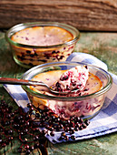 Small portions of elderberry and quark bakes in jars with spoons