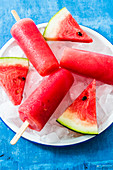 Watermelon ice lollies with watermelon slices on ice