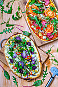 Gemüsepizza und Pizza mit Salami und Gemüse auf Holzbrett