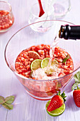 Champagne being added to strawberry punch