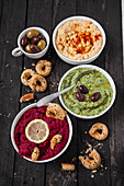 Hummus, spinach hummus and beetroot hummus with sesame seed bread rings