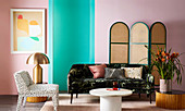 Chair, sofa, side tables and screen against pink and green wall in living room