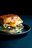 A burger with fried egg and ham