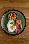 Englisches Frühstück mit Baked Beans, Spiegelei und Bacon
