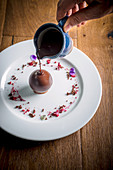 Warm Chocolate being poured over Chocolate Dessert for opening effect