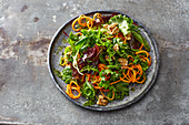 Green salad with walnuts and carrot spirals