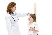 Doctor measuring girl on height chart