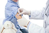 Doctor putting plaster on boy's arm after injection