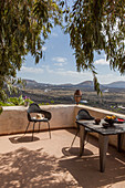 Tisch und Stühle auf mediterraner Terrasse mit Panorama