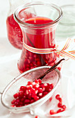 Homemade pomegranate vinegar in a jar with pomegranate seeds, vanilla and white balsamic vinegar
