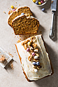 Easter carrot loaf cake decorated with mini eggs and walnuts