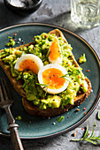Boiled eggs in the shape of a bunny rabbit face on smashed avocado on toast
