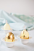 Bunnies on top of Easter eggs covered in gold leaf