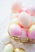 Pink eggs with gold leaf in wire basket