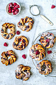 Wreaths of yeast dough with cinnamon and frozen berries sprinkled with powdered sugar