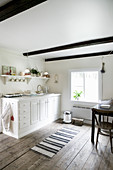 White kitchen counter in rustic kitchen-dining room with wooden floor