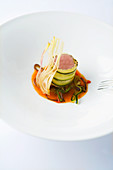 Rack of lamb wrapped in zucchini on peppers