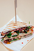 A club sandwich with chicken breast, bacon, egg and sriracha sauce