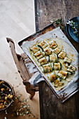 Ofengebackene Zucchiniröllchen mit Bröselkruste auf Ofenblech