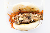 Steamed bun filled with char siu style pork belly, marinated carrots and toasted peanuts