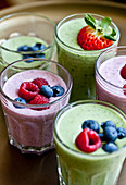 Berry smoothies and green smoothies, topped with fruit