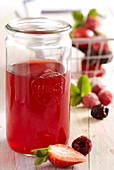 Homemade berry vinegar in a mason jar with rose wine and raspberry spirit