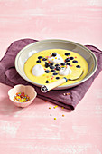 Custard soup with blueberries and meringues