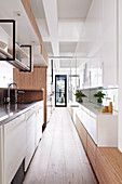 Narrow kitchen with glossy white fronts