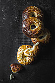 Closeup shot of delicious fresh brioche crowns lying on marble tabletop in dark room
