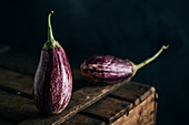 Graffiti eggplant on wooden table and dark background
