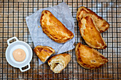 Empanadas made of puff pastry on a cooling grid
