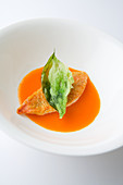 Red mullet on red pepper sauce with fried basil