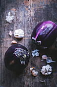Round eggplants and garlic on a wooden surface