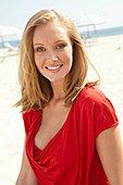 Blonde Frau in rotem Top am Strand