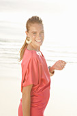 Blonde Frau in rotem Kleid am Strand