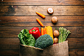 Linen sack with assorted vegetables on table