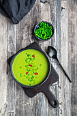 Pea soup with spring onions and chilli topping
