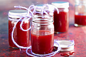 Homemade plum syrup with cinnamon in preserving jars