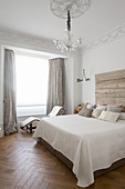 Doppelbett mit rustikalem Betthaupt aus Holz und Liege im Schlafzimmer