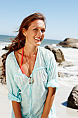 A brunette woman wearing a light-blue beach dress by the sea