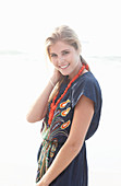 A young blonde woman with necklace wearing a beach dress