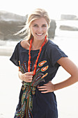 A young blonde woman with necklace wearing a beach dress