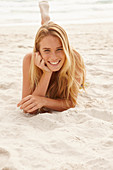 A blonde woman lying on a beach