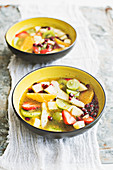 Colourful fruit salad in an orange and mint sauce