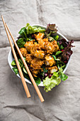 Diced tofu with a spicy cornflake coating on a bed of salad
